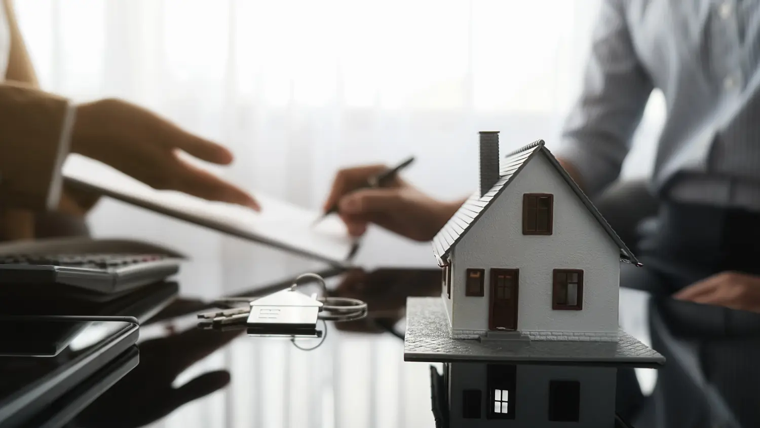 Immobilienmakler und Kunde unterzeichnen einen Vertrag über den Kauf eines Hauses, eine Versicherung oder ein Immobiliendarlehen.